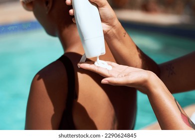 Close up of woman squeezing sunscreen onto hand, apply friends back sitting pool