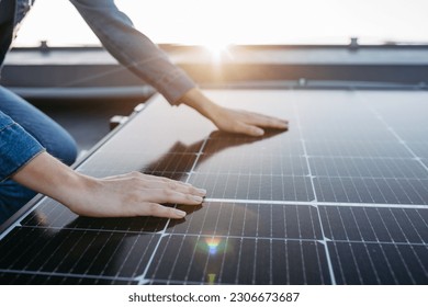 Close up of woman touching solar panels on the roof. - Shutterstock ID 2306673687