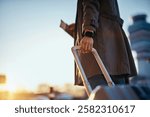 Close up of woman with travel bag at the airport at sunset. Copy space. 