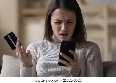 Close up woman try pay bill online, use credit card and phone, experiences failure feels angry. Money overspend, problem with account security, unsuccessful electronic shopping, fraud and scam concept