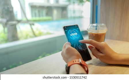 Close Up Of Woman Using A Phone With ESIM Technology. Mobile Device With A Chip On A Circuit Board Art.eSIM(Embedded SIM) - Electronic Sim Phone New Mobile Communication Technology.