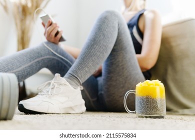 Close Up Of Woman Using Smartphone To Count Calories For Post Workout Chia Pudding. Panna Cotta Desserts.