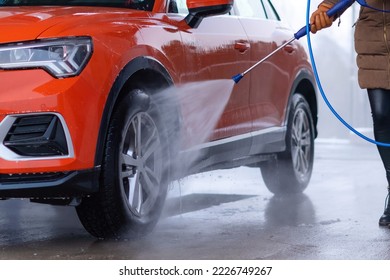 Close up of woman washing the car with high pressure water at self service car wash. - Shutterstock ID 2226749267