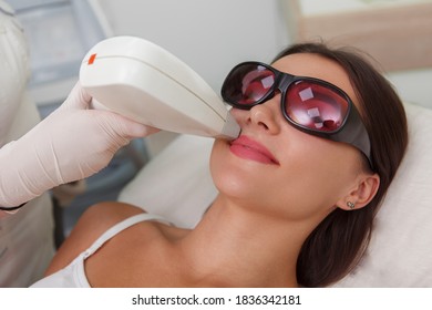 Close Up Of A Woman Wearing Protective Eyeglasses, Getting Upper Lip Hair Laser Remover By Cosmetologist