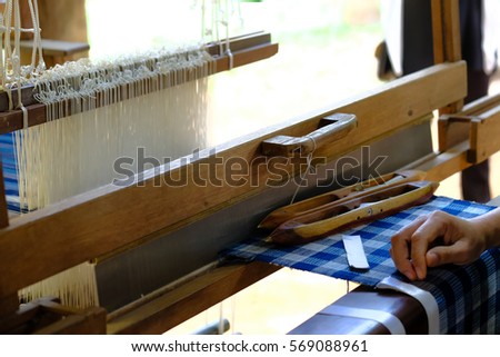 Close up of woman weaving silk from hand weaving machine, Abstract background - selective focus, Thailand