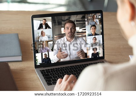 Close up of woman worker talk brainstorm on video call on computer with diverse colleagues, have online team briefing together, female employee engaged in webcam conference on laptop with coworkers
