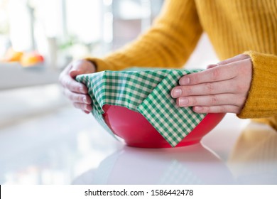 Close Up Of Woman Wrapping Food Bowl In Reusable Environmentally Friendly Beeswax Wrap