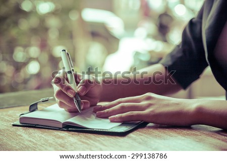 close up of woman writing her journal
