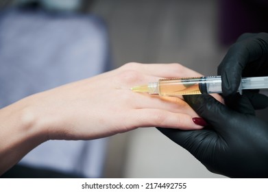 Close Up Of Woman's Arm, Which Piercing With Syringe To Inject Special Substances To Rejuvenate Skin And To Stop Process Of Senescence. Professional Injectable Cosmetology.