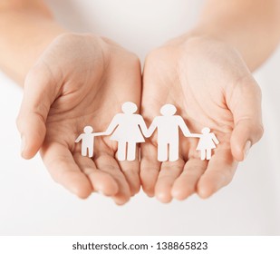 close up of womans cupped hands showing paper man family - Shutterstock ID 138865823
