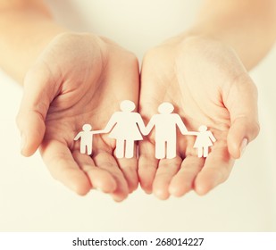 close up of womans cupped hands showing paper man family - Shutterstock ID 268014227
