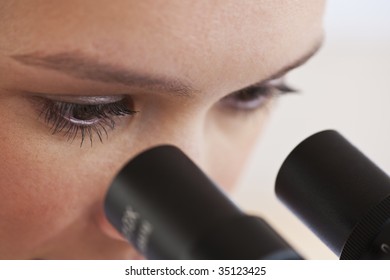 Close Up Of Woman's Eyes Looking Through Microscope