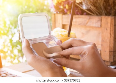 Close Up Of Woman's Hand Applying Face Powder In Office.