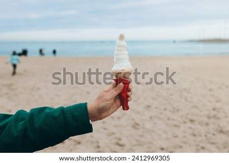 Close up womans hand with delicious white ice cream in waffle cone outdoors. Food banner. Ice-cream solves everything