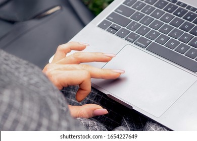 Close up of woman's hand and finger using touchpad of laptop. Female hand is using a touchpad on a laptop close up. Lifestyle and technology concept.