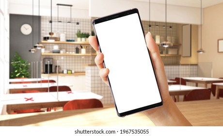 Close Up Of A Woman's Hand Hold A Smartphone With White Blank Screen And 3D Empty Restaurant Seats In Background. Mobile Application, Business, Services, Food Delivery, Apps, Covid 19, Stop Spreading.