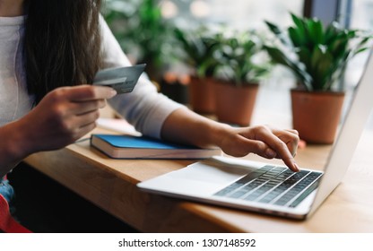 Close Up Woman's Hand Holding Credit Card Using Laptop Computer For Online Shopping With Cash Back, Discount Sales, Low Prices. Online Store Concept. Female Planning Travel And Booking Tickets.