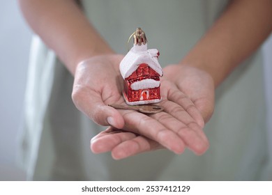 close up of woman's hand with mini house and house key in her hand. concept of buying or selling red and snowy christmas house. discount to buy house in december christmas day. - Powered by Shutterstock