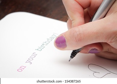 Close Up Of A Woman's Hand Writing A Birthday Card