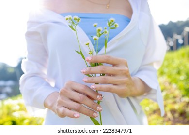 Close up of woman's hands holding bouquet of fresh daisies flower  in front of her. Woman stand holding a flowers in garden, with focus on a flowers. Woman with bunch of field flowers in hands.  - Powered by Shutterstock