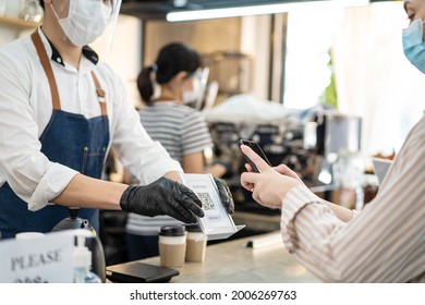 Close up of woman's hands use mobile phone scanning QR code in café. Young girl customer make quick and easy contactless payment to pay for takeaway drink from barista waiter during Covid-19 Pandemic. - Powered by Shutterstock