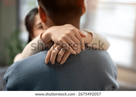 Close up of a woman's hands with wedding ring holding hugging a man's neck standing in a living room. Happy marriage, Love Language, Relationship Goal.