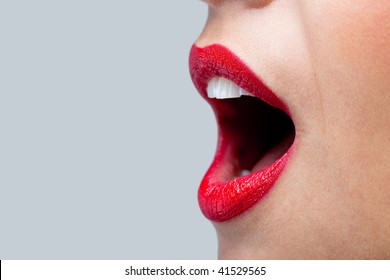 Close Up Of A Womans Mouth Wide Open With Bright Red Lipstick On Her Lips.