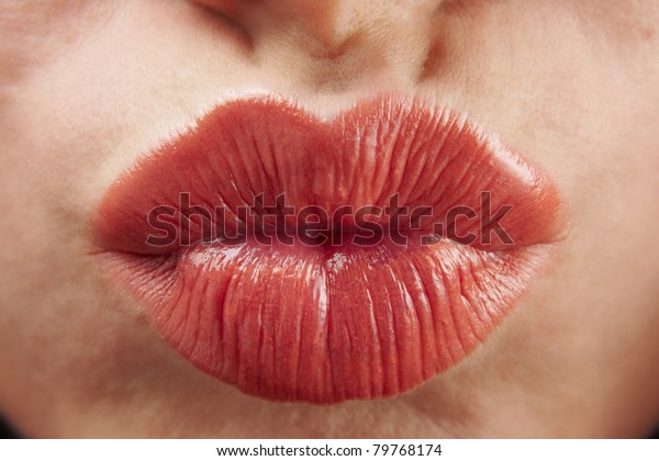close up of womans pouting lips with red lipstick