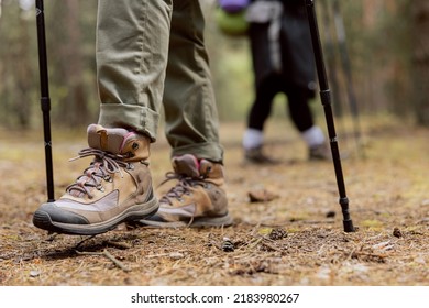 Close up of woman's rugged hiking boots and jeans on a leaf covered forest trail. Hiker in the middle of image with forest behind her. - Powered by Shutterstock