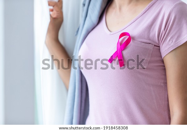 Close up of\
women disease mammary cancer patient  with pink ribbon wearing\
headscarf After treatment to chemotherapy at the window In the\
bedroom at the\
house,healthcare,medicine