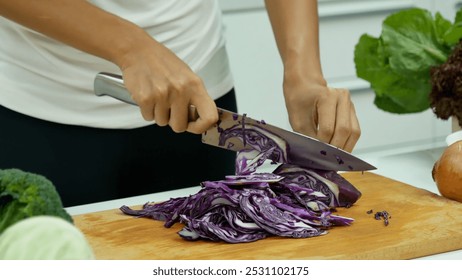 Close up Women hand cutting purple cabbage prepare fruit vegetables green bell pepper carrot tomato at home kitchen. Crop Woman hands use knife cut purple cabbage wooden cutting board vegan healthy - Powered by Shutterstock