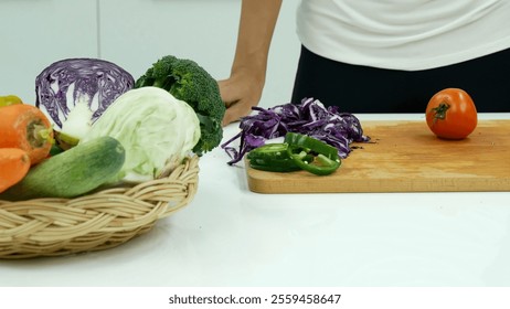 Close up Women hand cutting purple cabbage prepare fruit vegetables green bell pepper carrot tomato at home kitchen. Crop Woman hands use knife cut purple cabbage wooden cutting board vegan healthy - Powered by Shutterstock