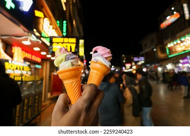 Close up of women hand holding delicious ice cream waffle cone with vanilla chocolate cookies and Cream. Indian soft serve ice cream in Manali Mall road Shimla Himachal Pradesh India.