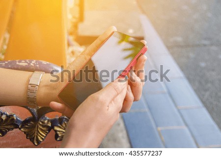Close up of a women hand holding a mobile phone outdoors,using smart phone for business
