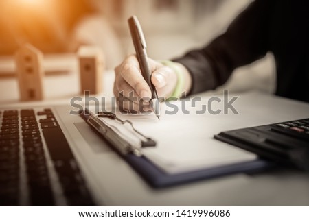 Close up women hand on writng on notebook and work with calculator 