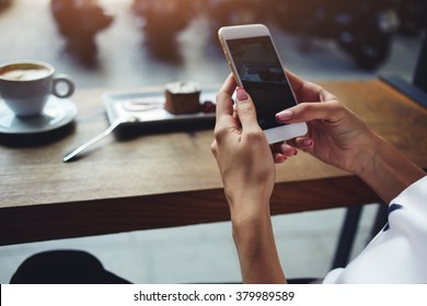 Close up of women's hands holding cell telephone with blank copy space scree for your advertising text message or promotional content, hipster girl watching video on mobile phone during coffee break  - Shutterstock ID 379989589