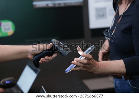 close up of women's hands with QR code reader on mobile phone