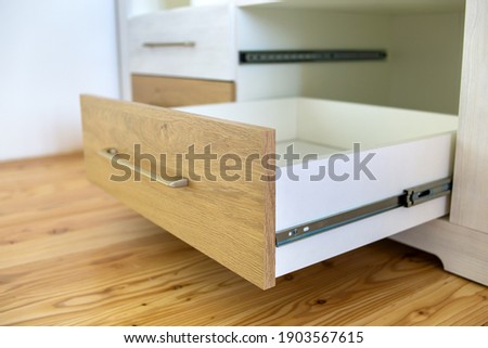 Close up of wooden drawer in contemporary cupboard cabinet.