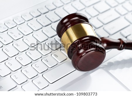 Close up of wooden gavel at the computer keyboard