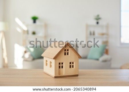 Close up of wooden house model on table in modern real estate agent office. Home building cottage maquette in realtor broker company. Bank property loan mortgage. Rent, realty concept. [[stock_photo]] © 