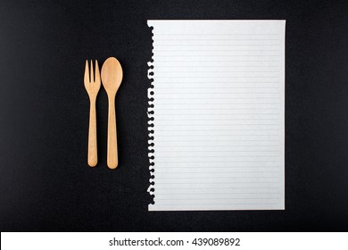 Close Up Wooden Spoon, Fork And Blank Paper On Black Table Top View