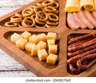 Close Up Of Wooden Tray With Meat And Cheese, Antipasto Snacks. Antipasto Cold Meat Dish With Breadsticks, Prosciutto, Ham, Ham Slices And Cheese On A Wooden Tray