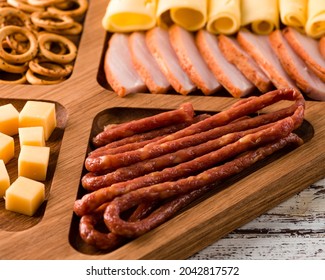 Close Up Of Wooden Tray With Meat And Cheese, Antipasto Snacks. Antipasto Cold Meat Dish With Breadsticks, Prosciutto, Ham, Ham Slices And Cheese On A Wooden Tray