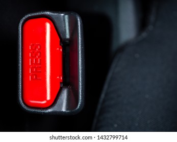 Close Up Of The Word Press On A Button Of A Seat Belt On Black Car Seat