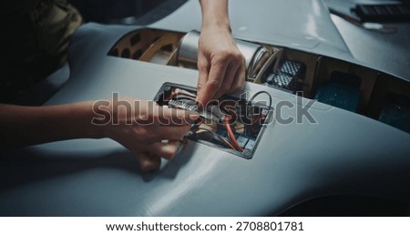 Close Up Worker Hand Assembling Critical Electronic Modules Into Next Generation Drone. It Represents Precision Manufacturing and Sophisticated Processes Involved in High Tech Defense Production.