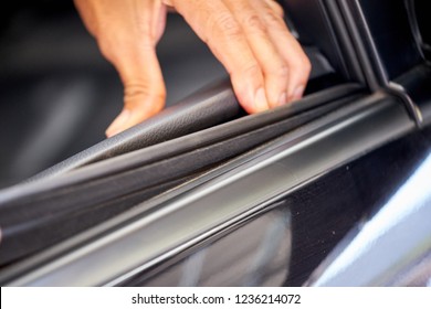 Close Up Of Worker Hand Remove Seal To Get Underneath  In The Interior Of The Car Using Finger To Get Under The Seal And Remove Dirt And Dust Before Car Window Tint Installation.