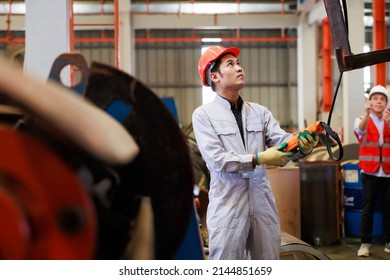 Close up worker hands control indoor overhead crane to lift up metal construction object on metal sheet factory. - Powered by Shutterstock