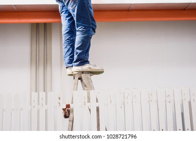 Close Up Worker Legs Standing On The Ladder At Construction Site.Risk Management Concept.