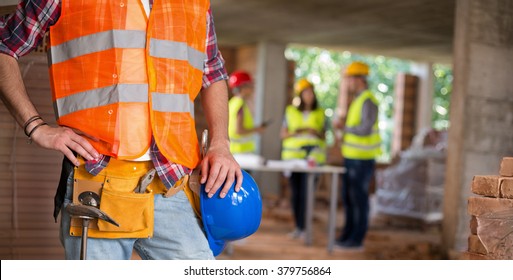 Close up of worker posing with working belt and tools