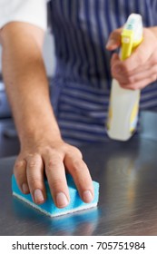 Close Up Of Worker In Restaurant Kitchen Cleaning Down After Service